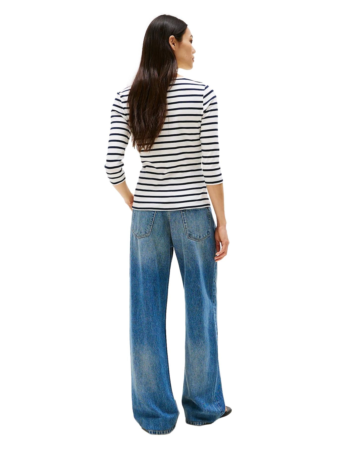 Hvit Tommy Hilfiger genser med båthals og slim fit, vist på en modell, laget av mykt bomullsmateriale.