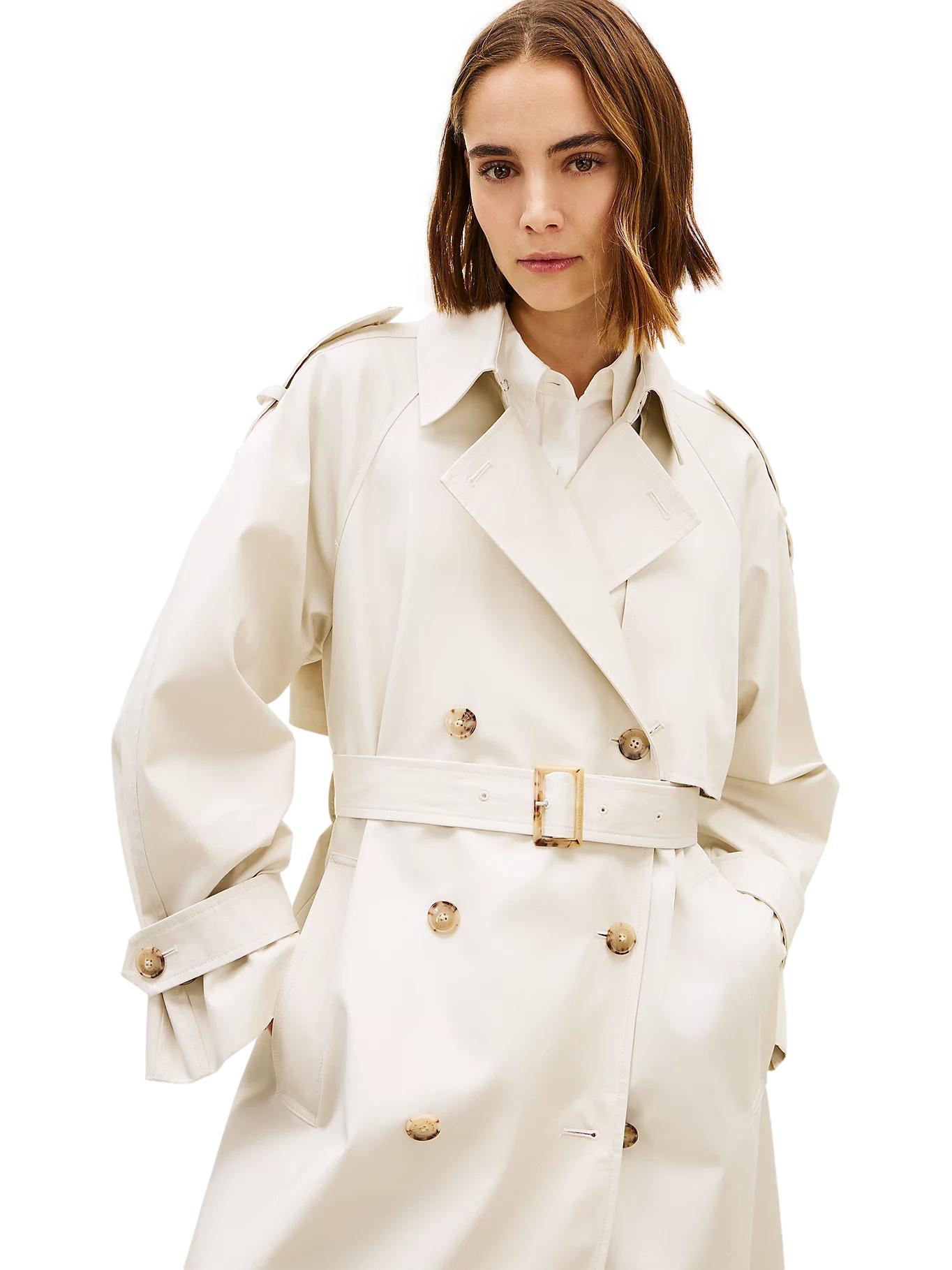 Lys-beige Tommy Hilfiger oversized bomulls trenchcoat jakke med bred krage og knapper, vist på modell.