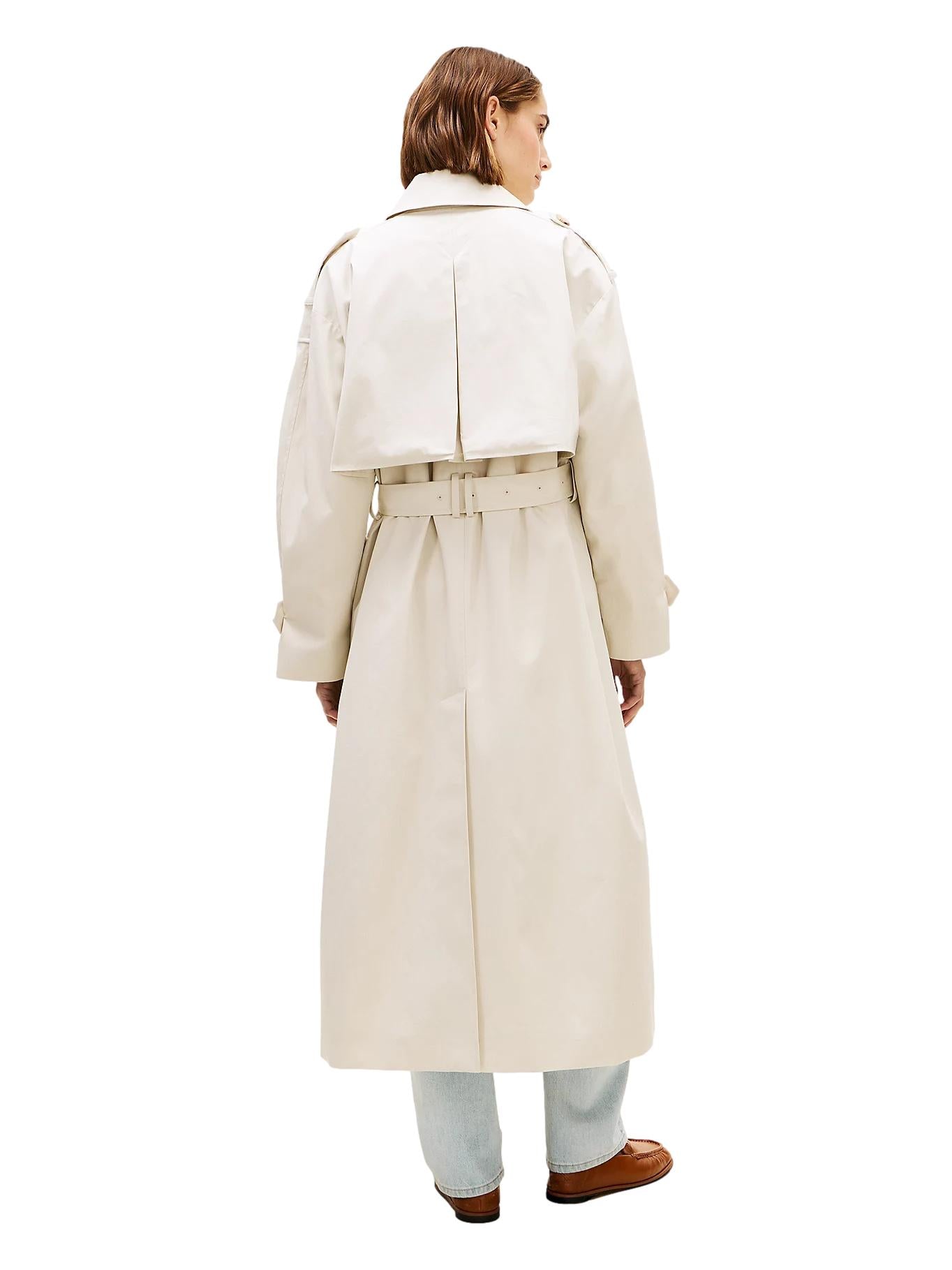 Lys-beige oversized bomulls trench coat jakke fra Tommy Hilfiger med klassisk design og belte, vist på modell.