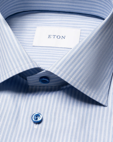 Eton stripet signatur twill skjorte i blå og hvite striper, her vist med krage og knappelukking.