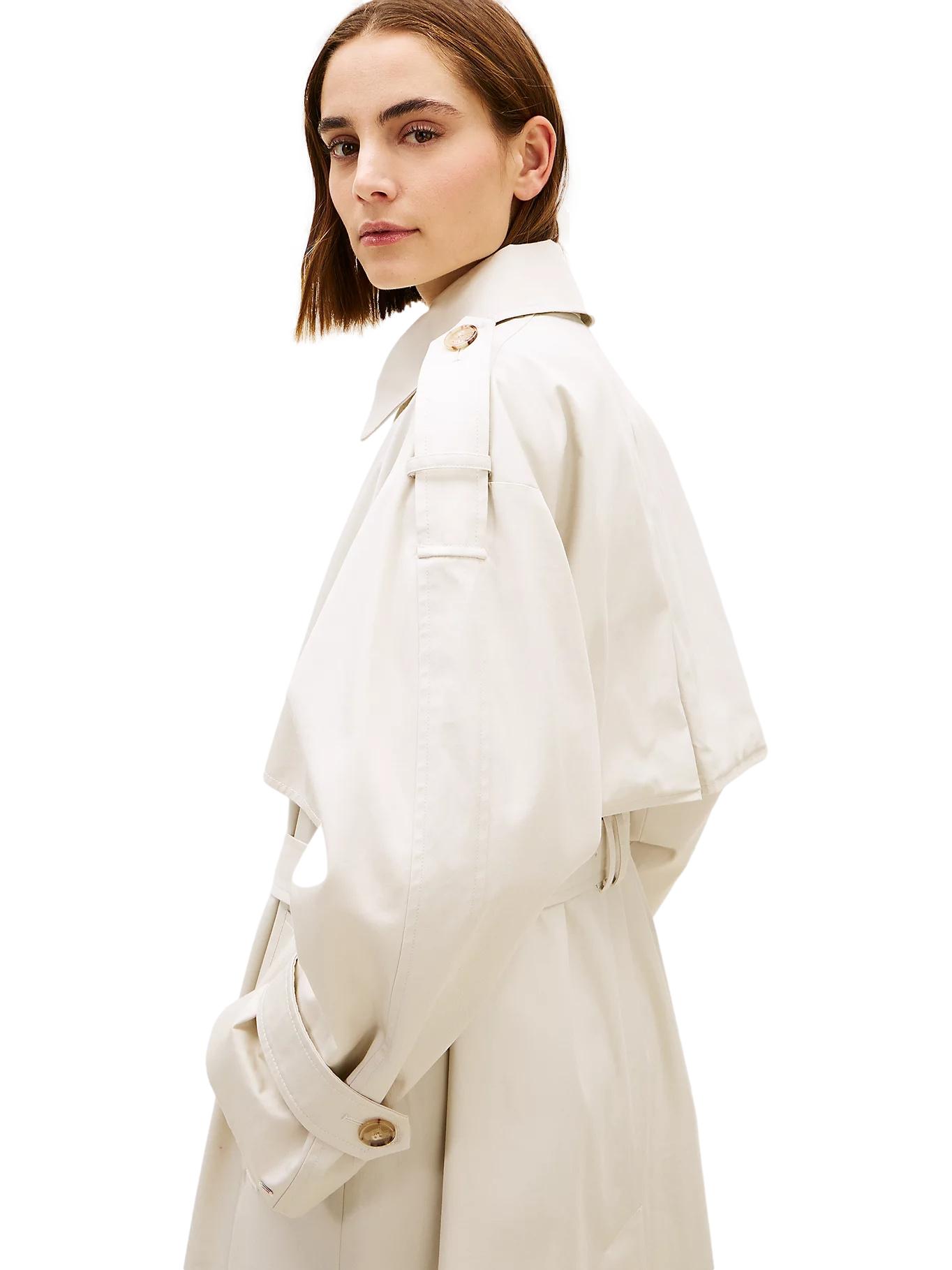 Lys-beige Tommy Hilfiger oversized bomullstrenchcoat jakke med klassisk design og belte, vist på modell.