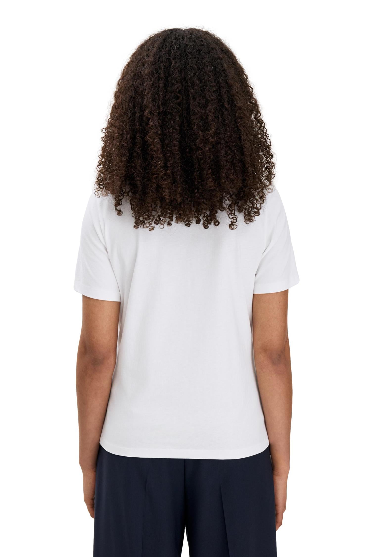 Hvitt Filippa K Filippa T-Shirt vist i et nærbilde som viser det enkle, komfortable designet og logoen foran.