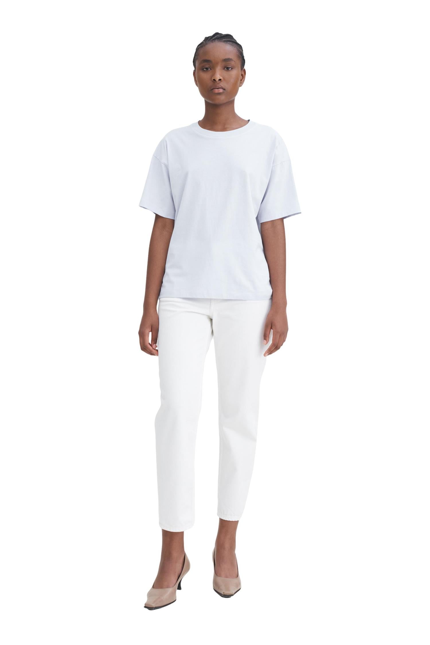Hvit Filippa K loose fit T-skjorte med rund hals og avslappet passform, vist på modell.