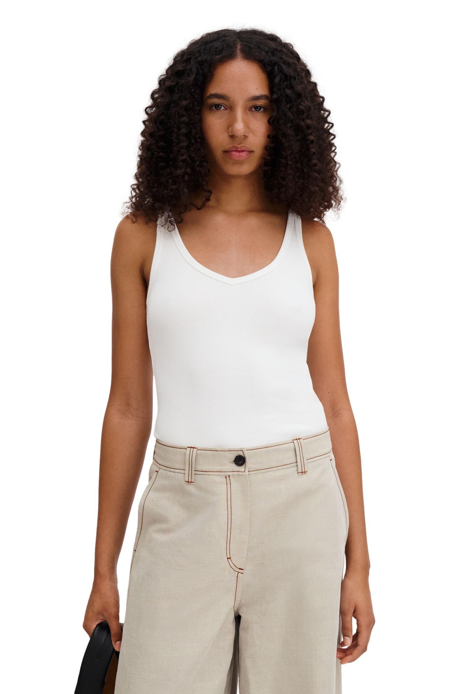 Hvit Filippa K V-hals tank-t-skjorte vist fra siden med mykt bomullsstoff og enkel design.