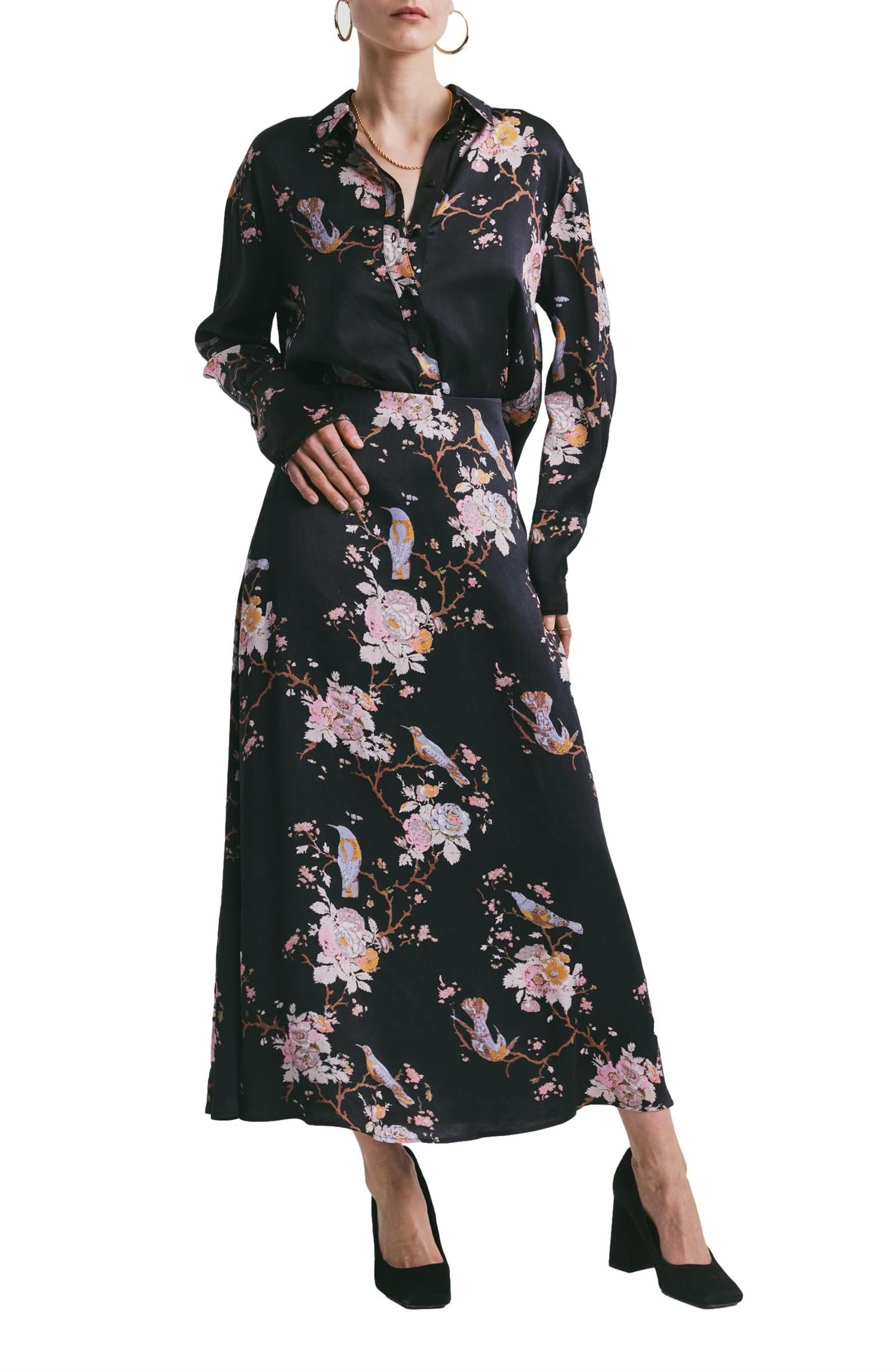 Sort satin skjørt fra By TiMo, elegant og glansfullt, vist på modell, perfekt for en sofistikert look.