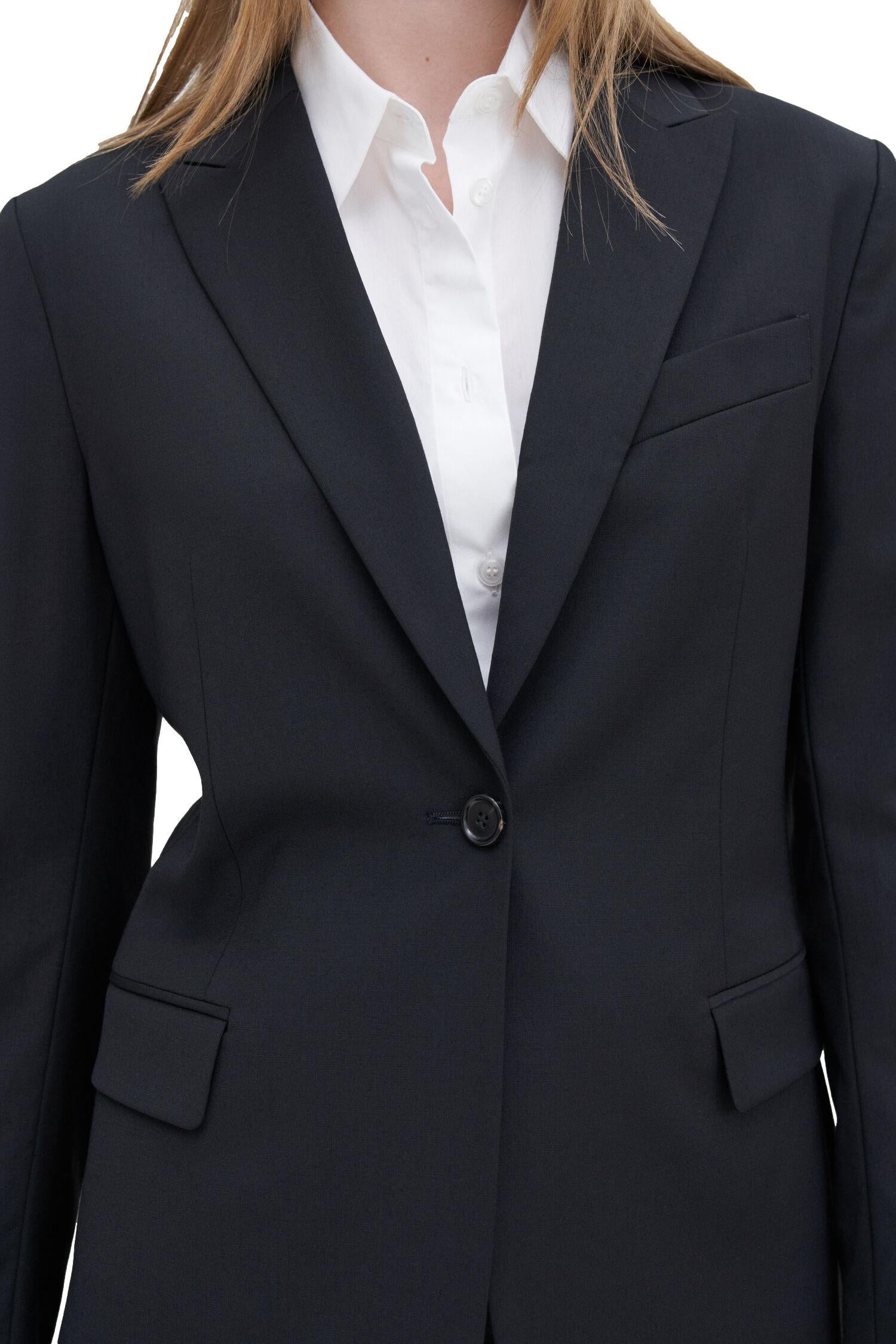 Filippa K Sasha ull blazer dressjakke i sort, elegant og stilfull, vist på modell foran hvit bakgrunn.